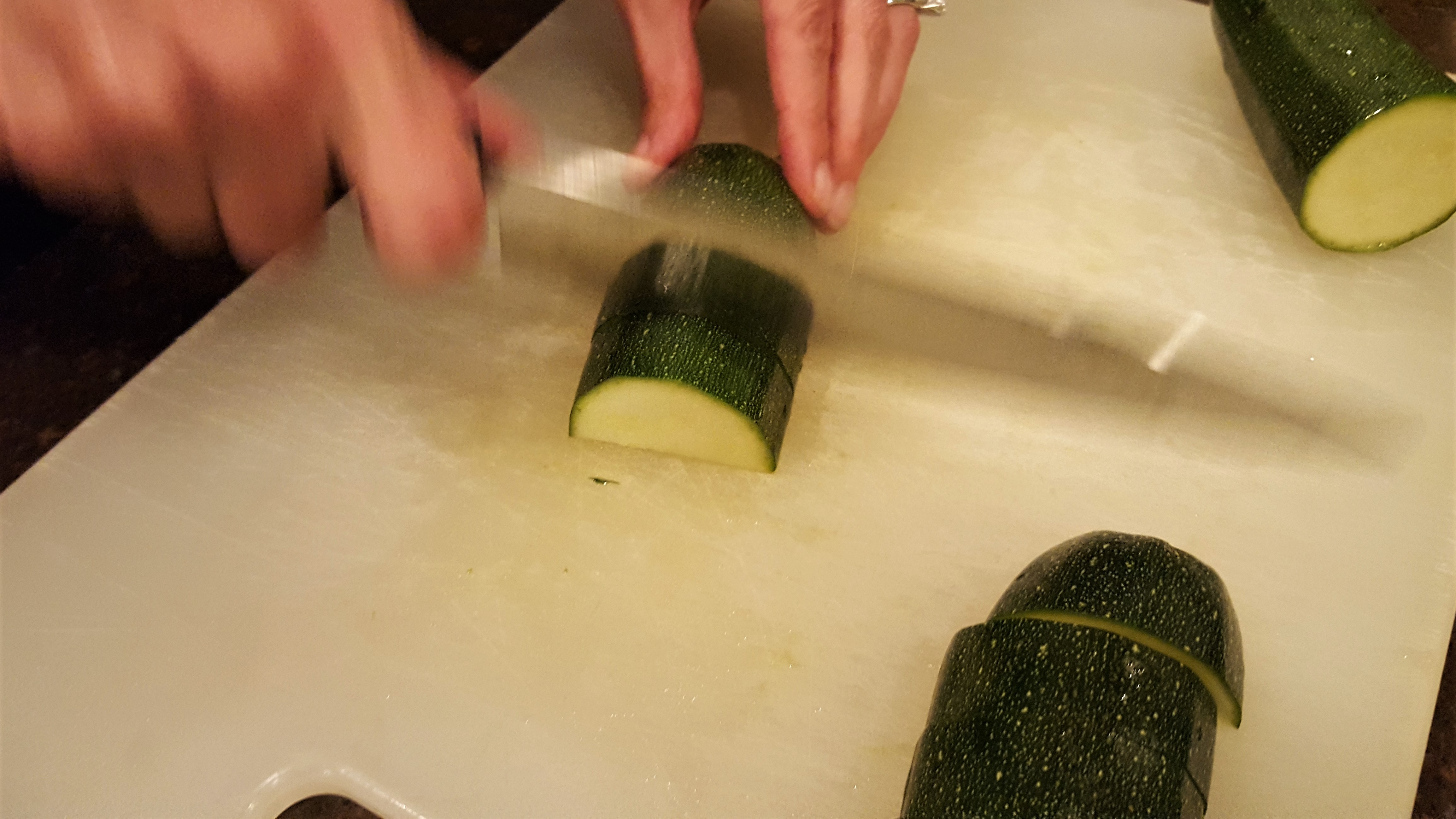 Me cutting up Zucchini Chunks for Roasted Balsamic Garlic Zucchini! Cutting up the Zucchini like this helps prevent you from cutting yourself - Dining in with Danielle